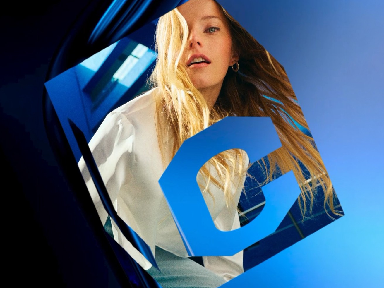 Model framed by La Cura’s blue 3D cube and C monogram
